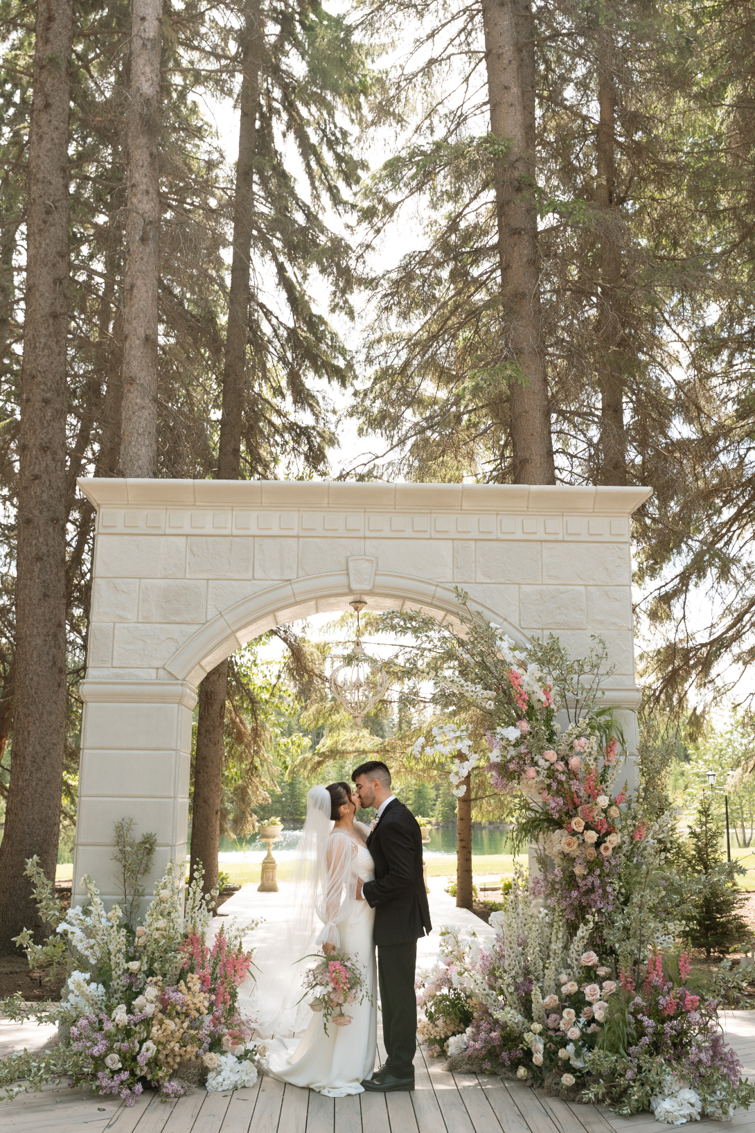 The couple standing underneath the stunning 12ft stone archway at the outdoor ceremony site