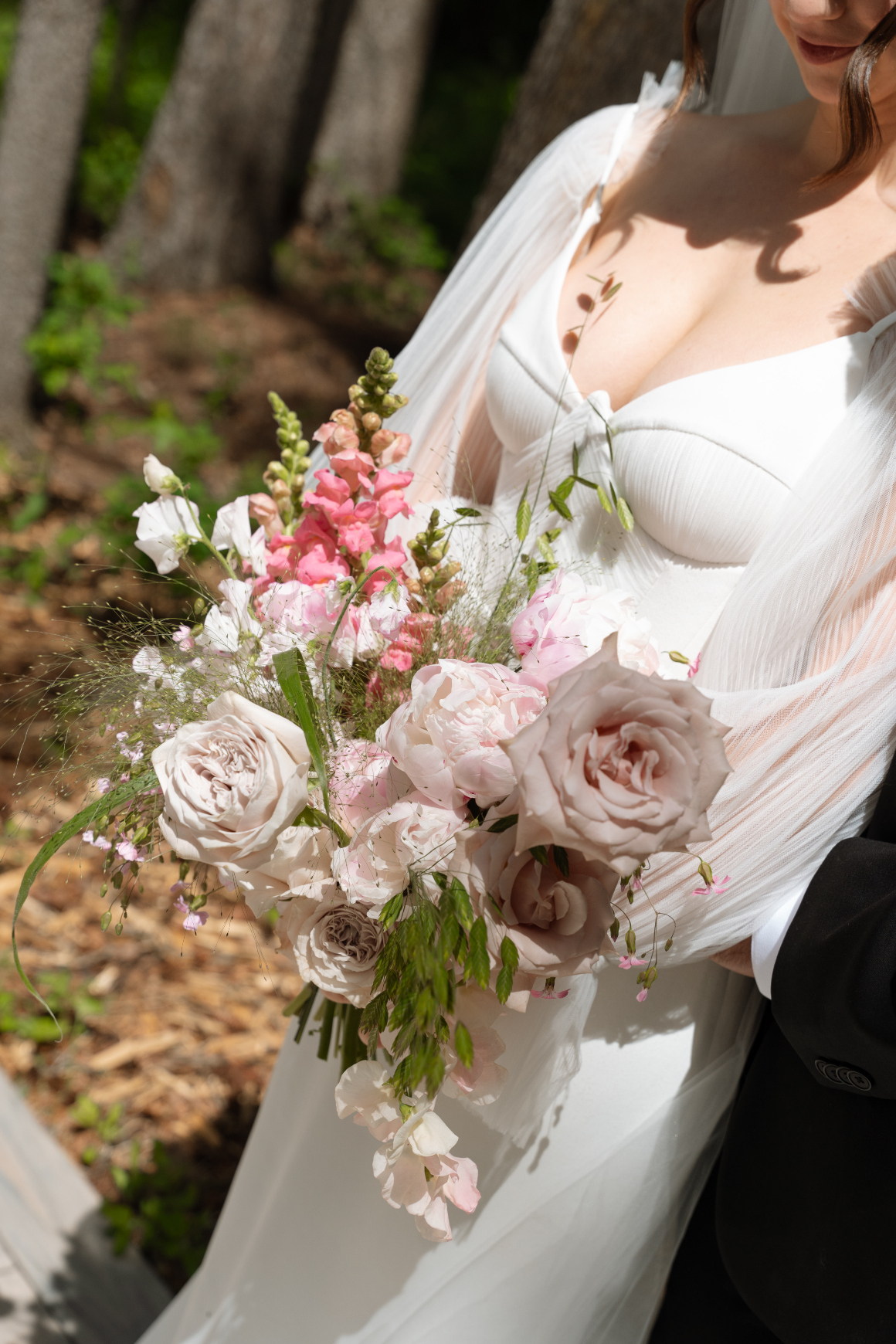 A photo of the bridal bouquet, featuring blush peonies, roses, snapdragons, sweet peas and decorative grasses.