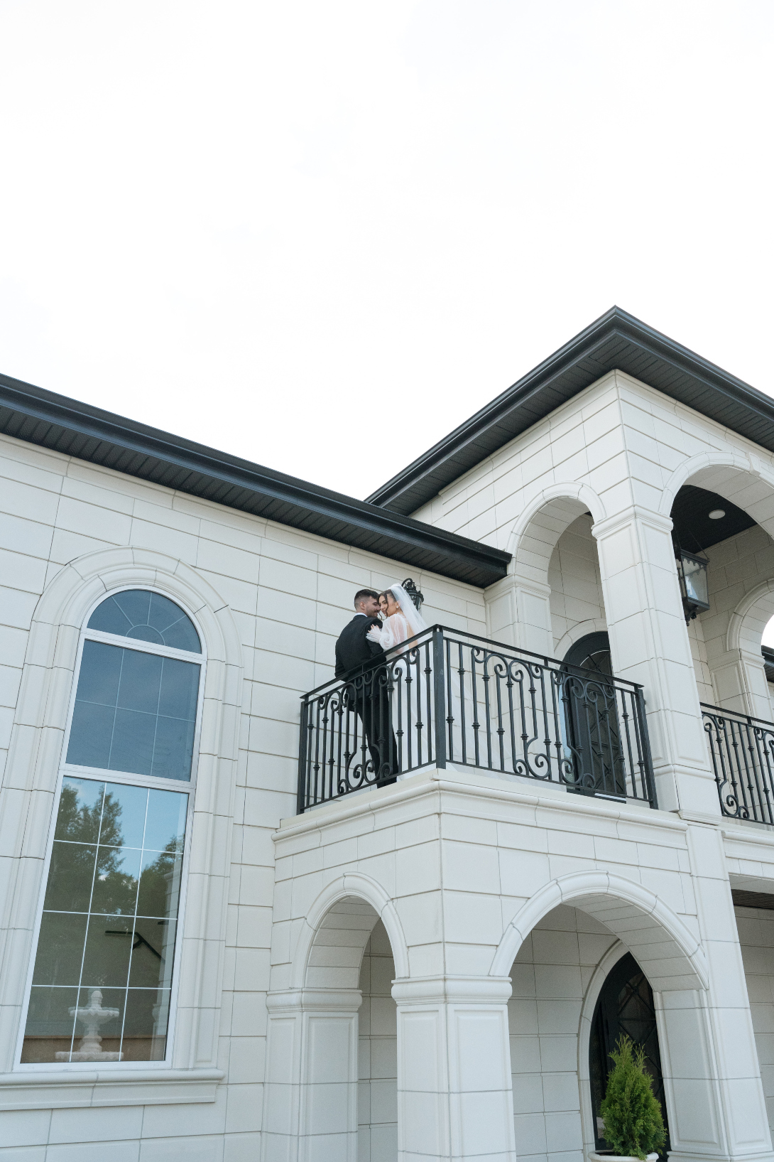 The couple kissing out on the balcony showcasing the beautiful details of the exterior.