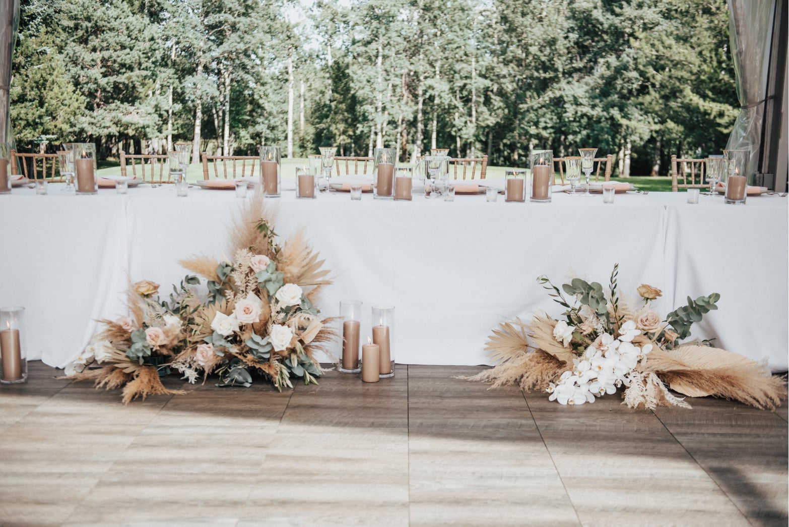 Closer view of the head table we can see more details of the big beautiful floral arrangements and clusters of tan pillar candles.