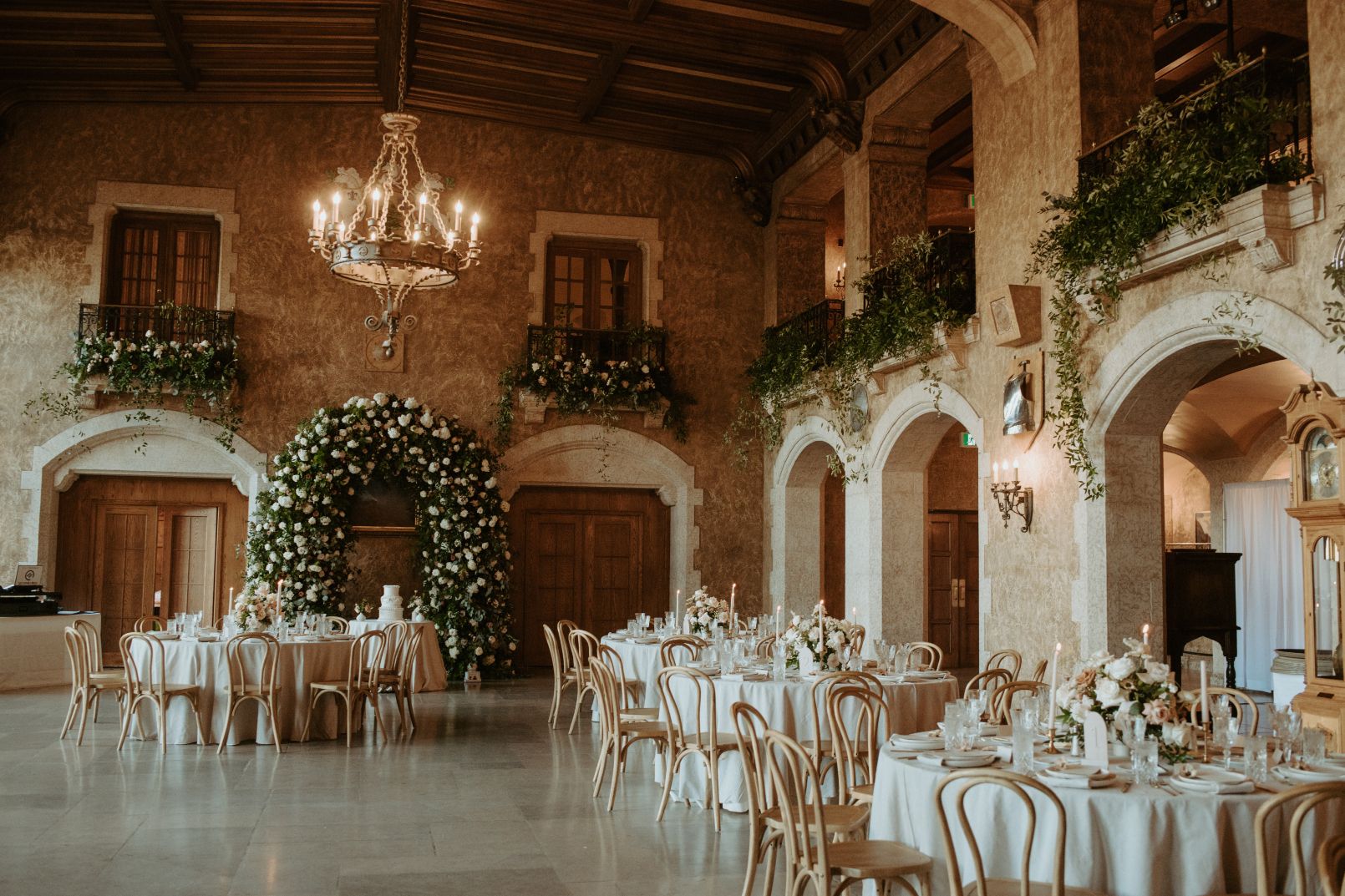 The reception space looking incredibly romantic with the overflowing balcony arrangements, large floral arch and gorgeous centrepieces.