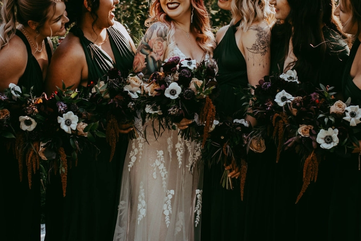 Haley and her bridesmaids standing closely, the focal point being their bouquets and smiling faces.