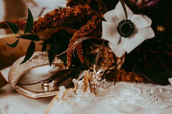 A close up shot of Haley's bridal accessories, shoes, rings, hair clip and bridal bouquet.