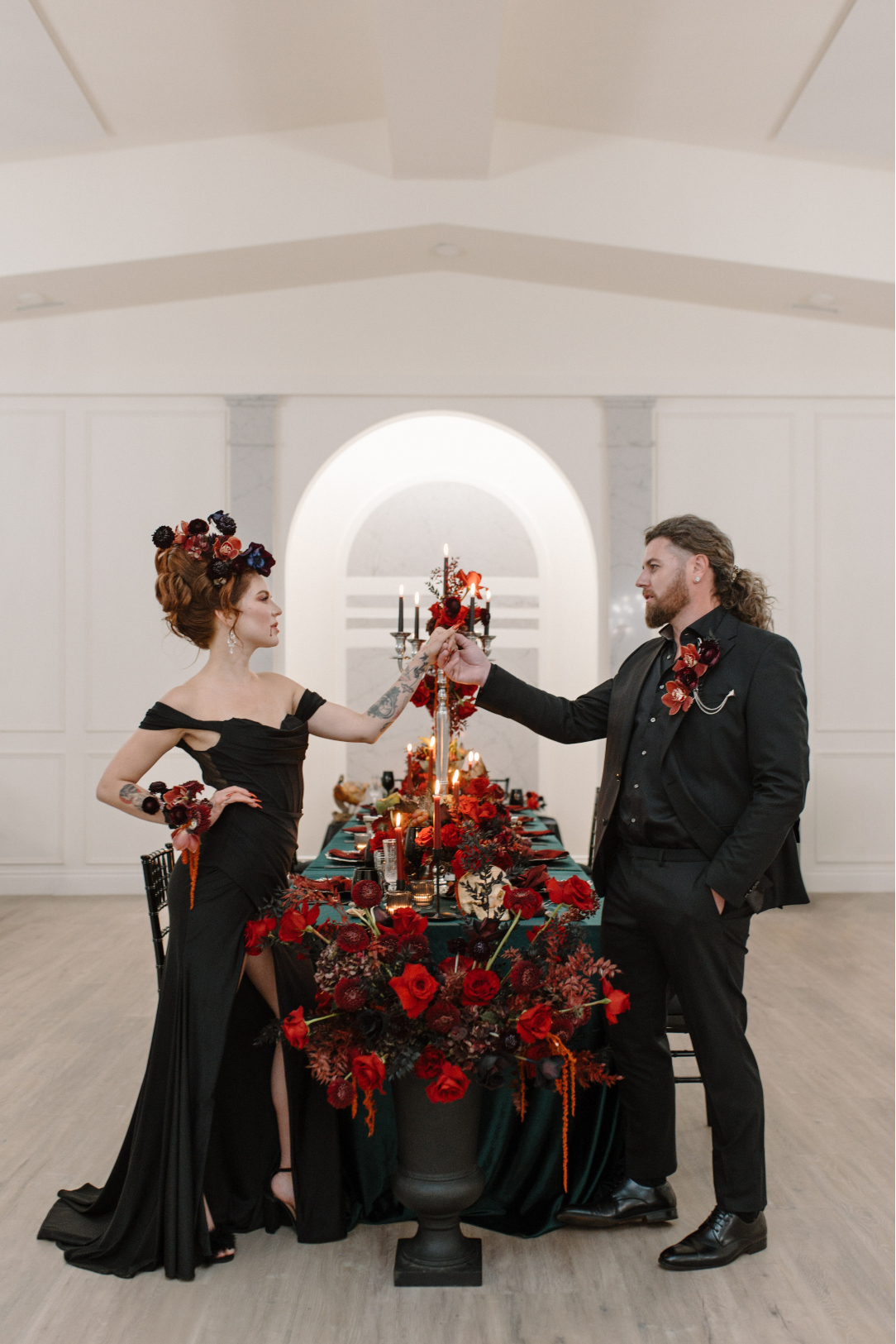 Dracula and his bride stand facing each other on opposite sides of the stunning table, staring into each other's eyes and clasping hands.