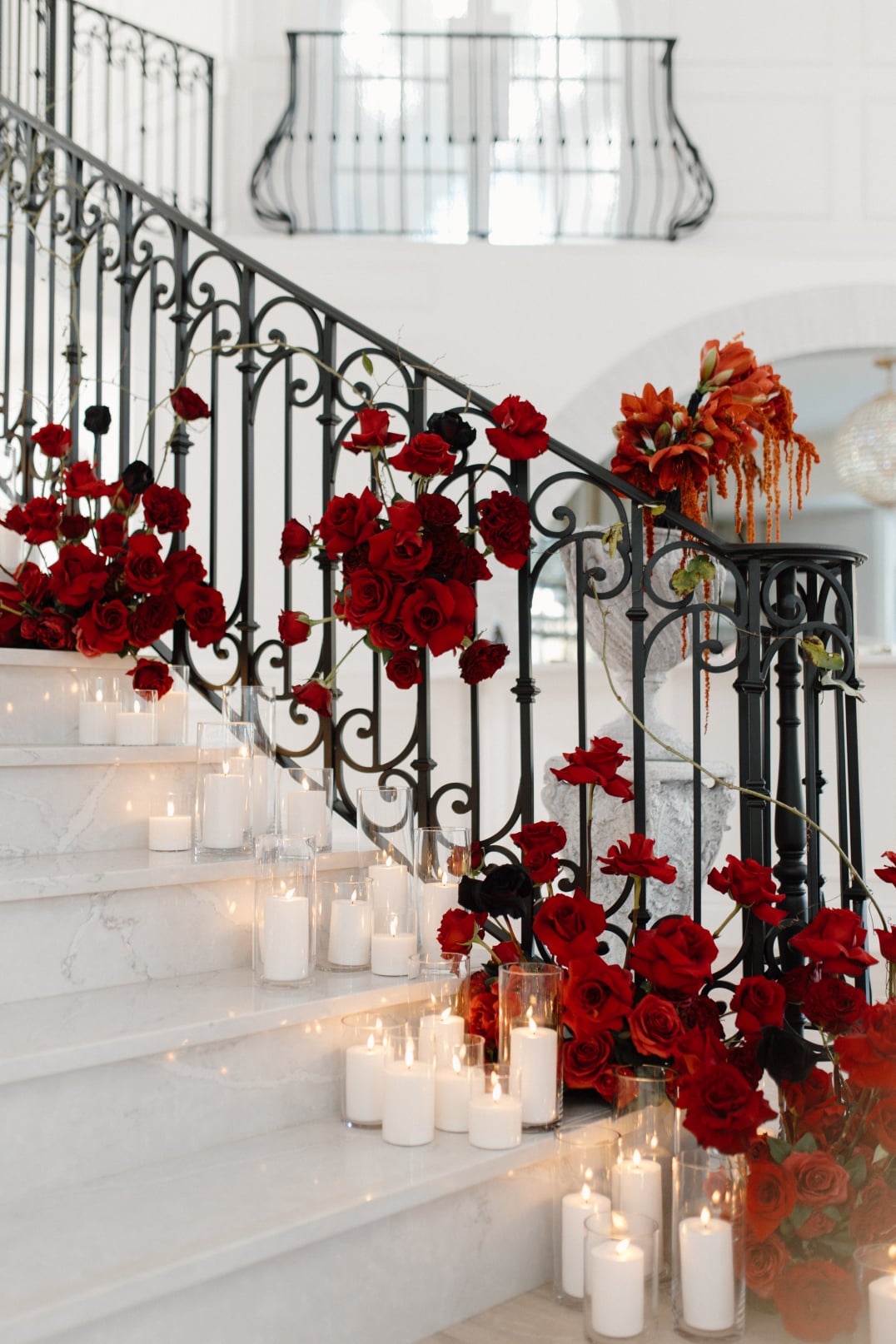 Showcasing the phenomenal red arrangements not only on the steps but attached on to the railing along with all the pillar candles.