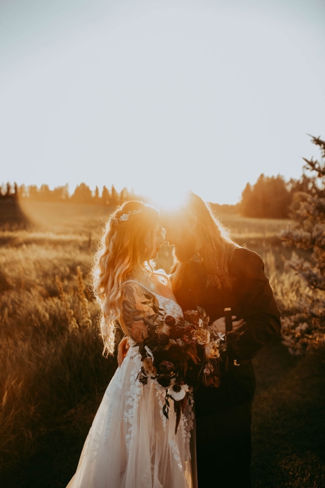 A gorgeous photo of Haley and Greg standing closely together as the setting sun shines behind them.