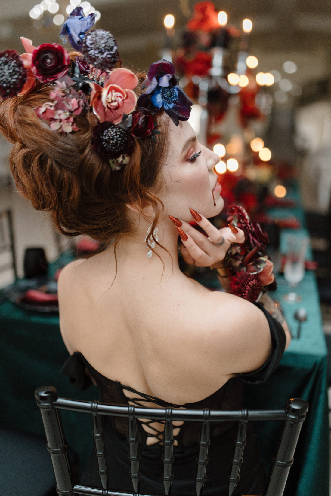 Dracula's bride from behind with her head turned to the side showcasing her stunning hairstyle, hairpiece and make up.