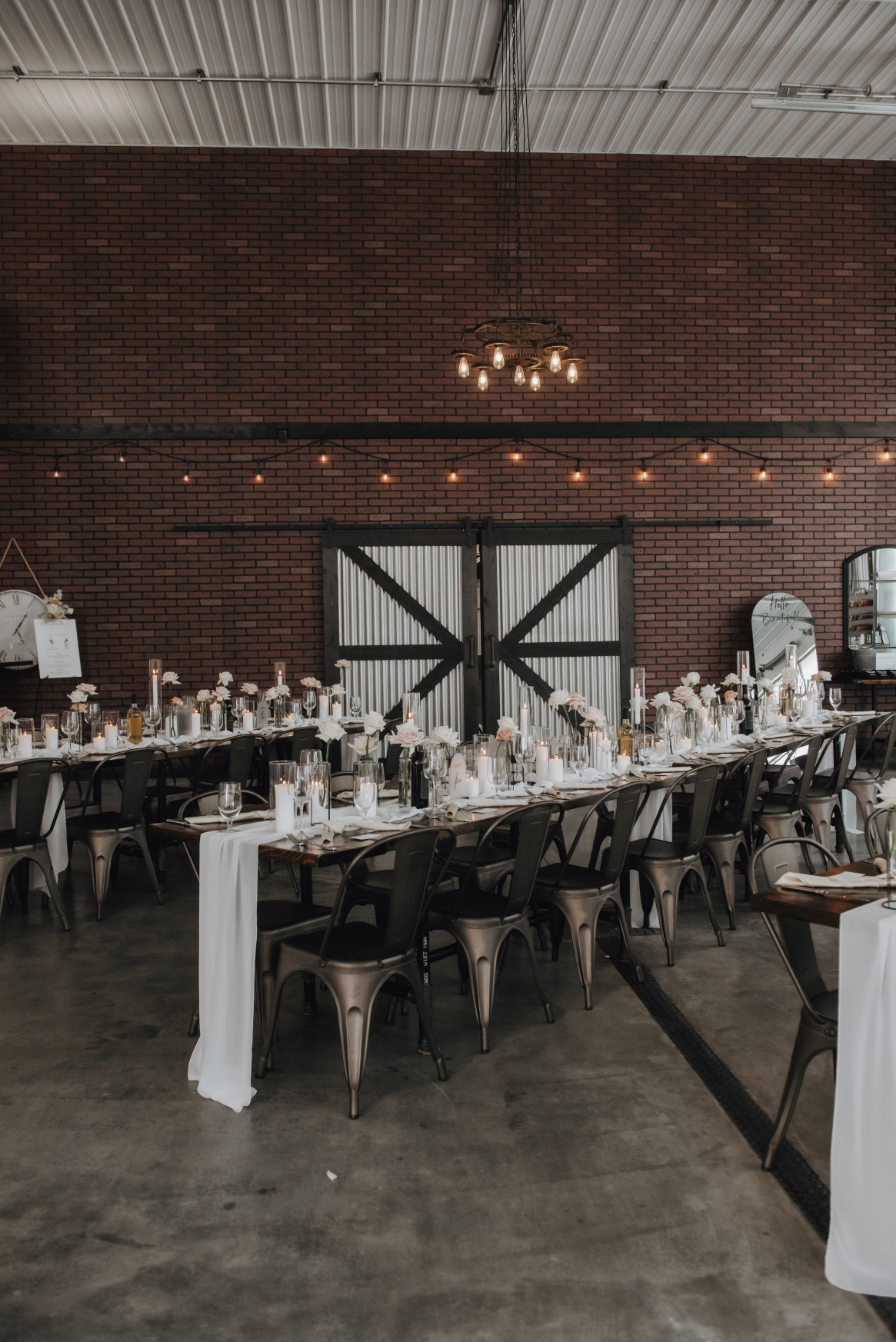 The back wall of 52 North features a stunning brick work, a gorgeous contrast to the white table runners, candles and flowers on the guest tables.