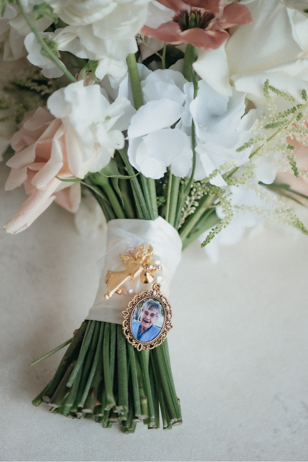 A beautiful keepsake locket secured onto the stem wrap of the bridal bouquet in memory of someone special who could not be with them on their big day.