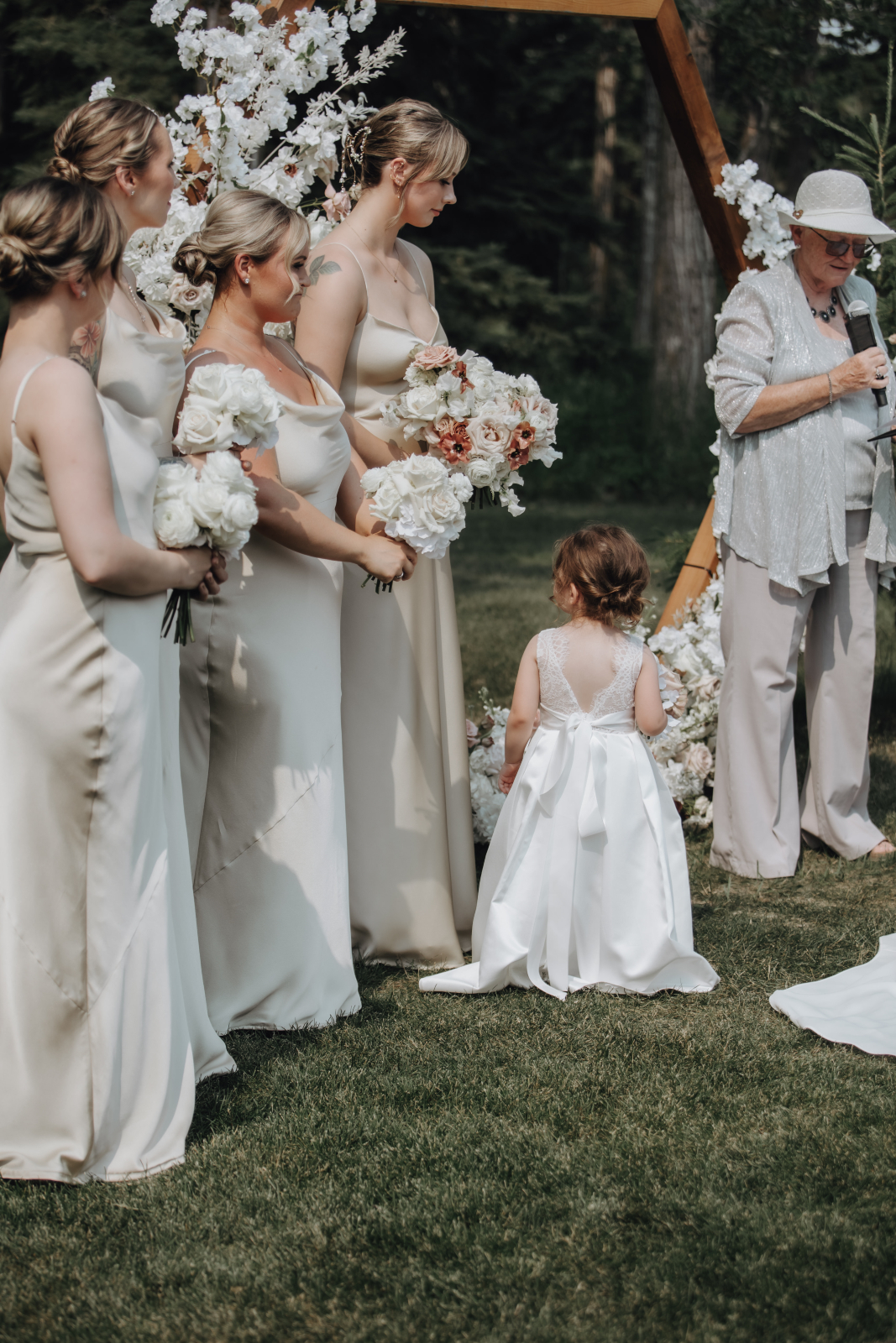 The bridesmaids, flower girl all standing together during the ceremony with their bouquets.