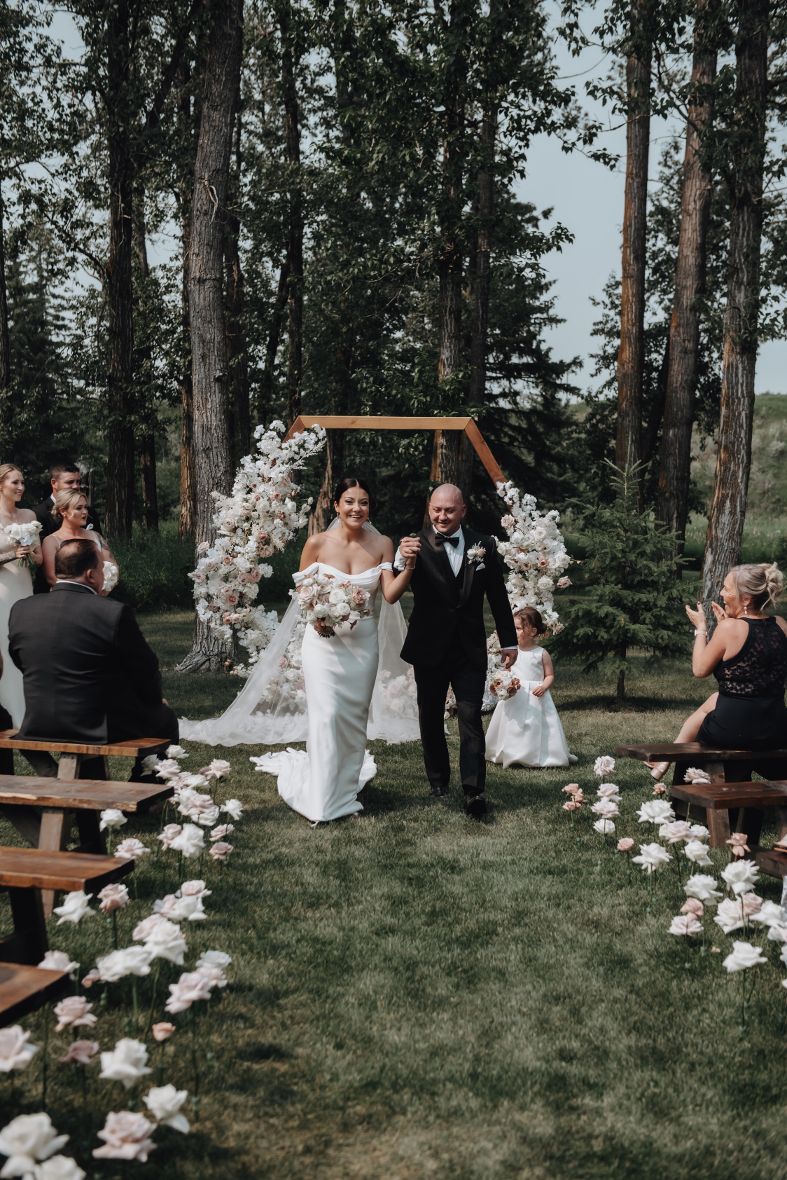 The beautiful couple exiting the ceremony, between the rows of roses!