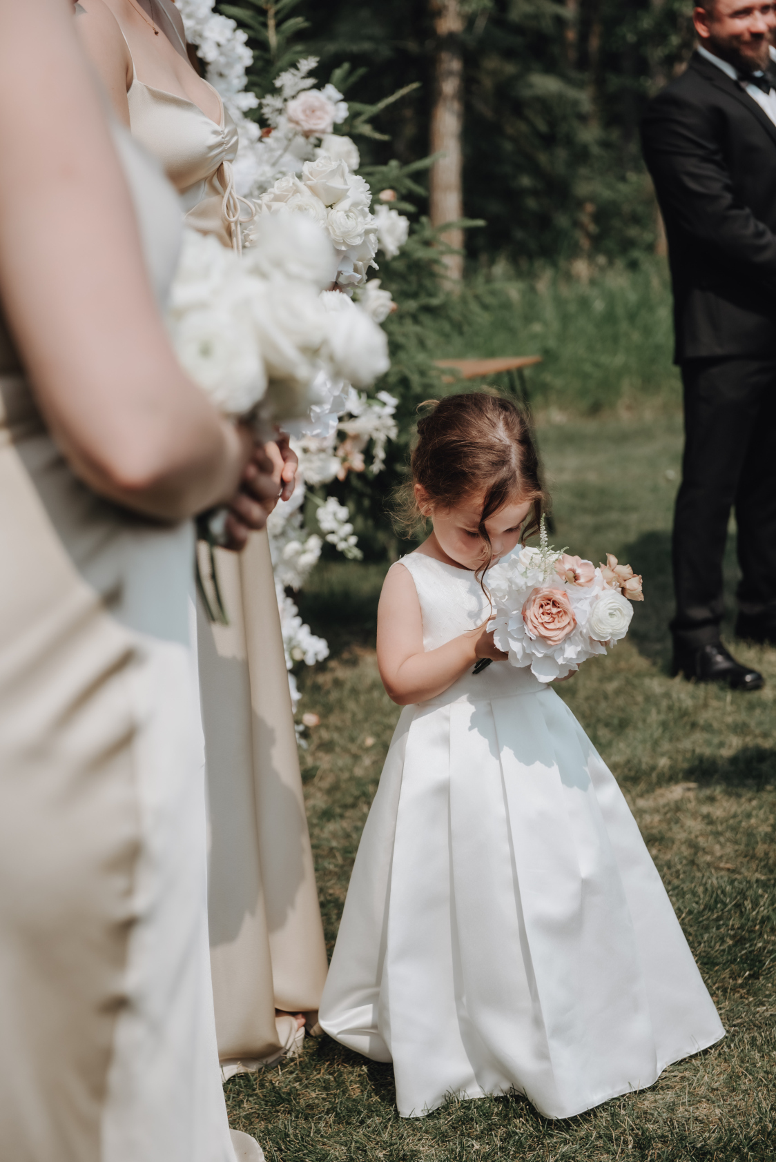 The adorable flower girl sniffing her precious little posy bouquet.