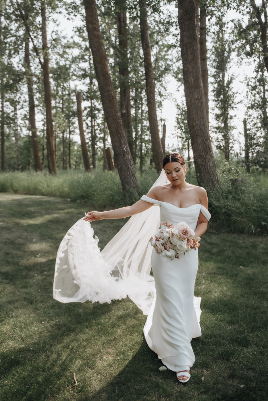 Kristen is walking with her bouquet, looking absolutely radiant as she holds her stunning veil trailing it along with her.
