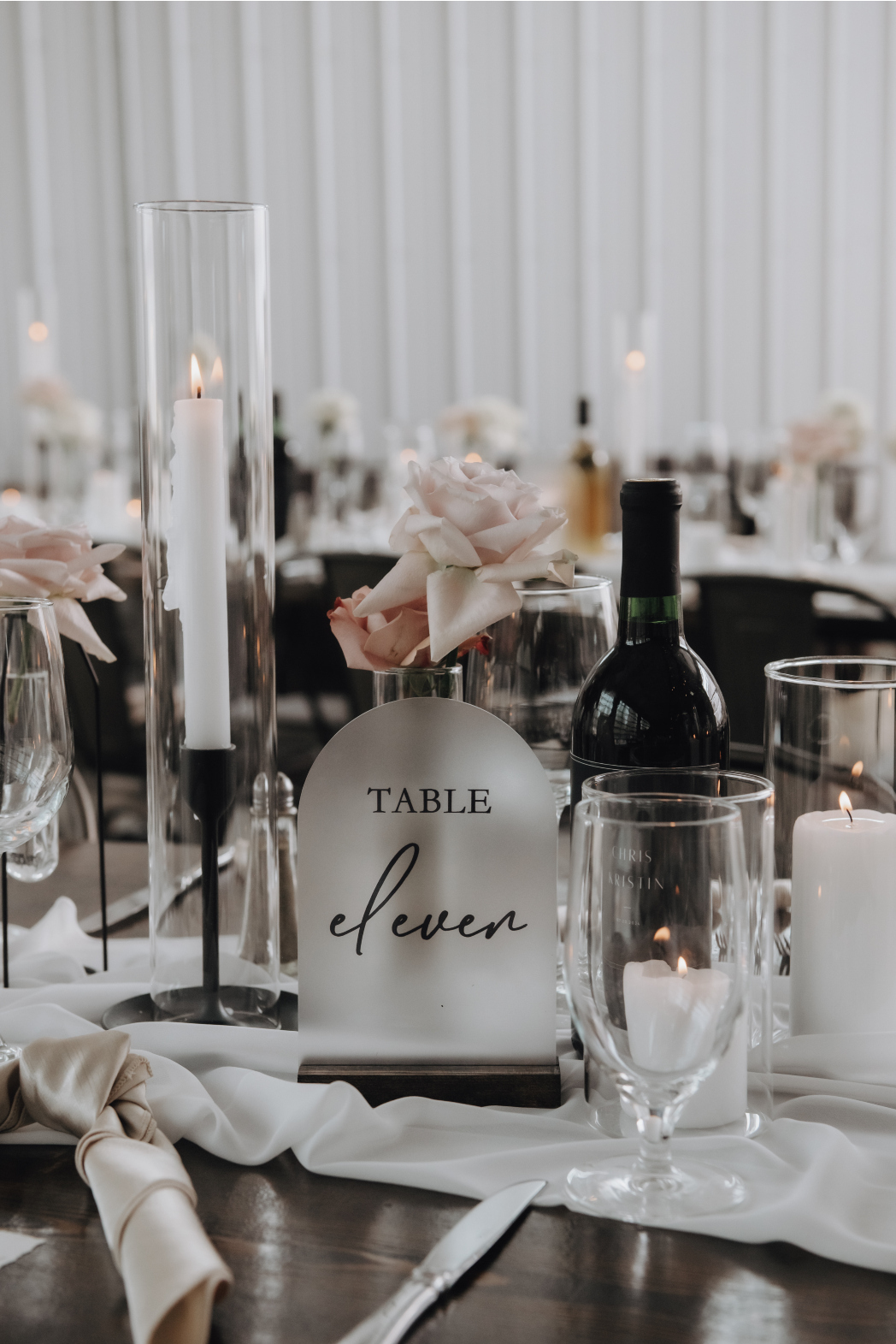 A pretty curved frosted glass with the table number etched onto it, tucked among the bud vases and candles.