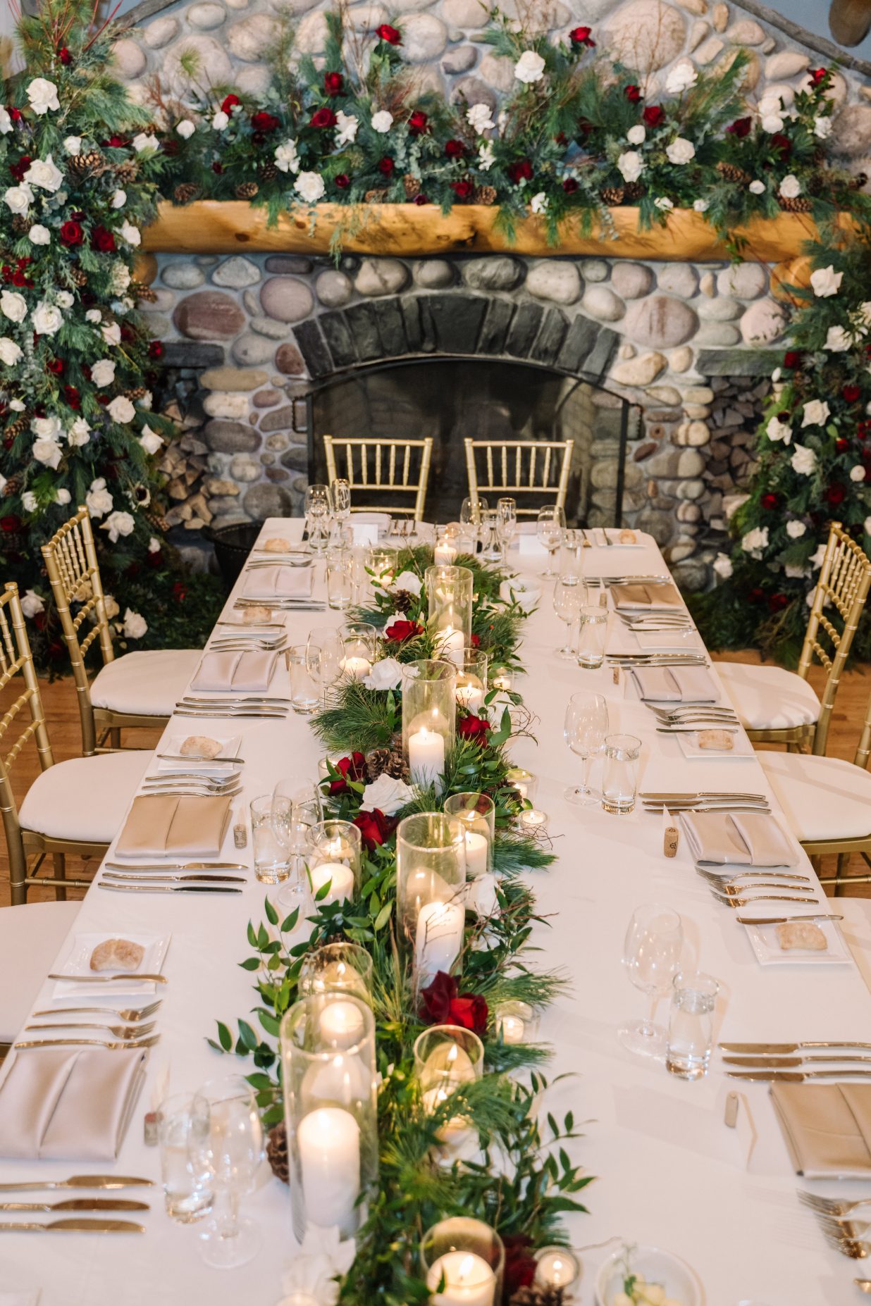 Head Table Design A very romantic tablescape for the head table with an elaborate floral table runner, and the stone fireplace decked out with extraordinary floral designs.