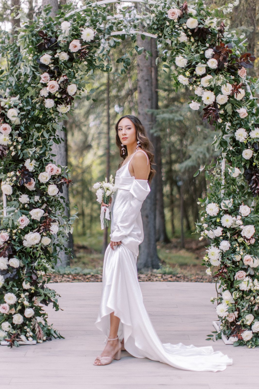 A modern satiny gown with a sleek silhouette and drapey detached sleeves.