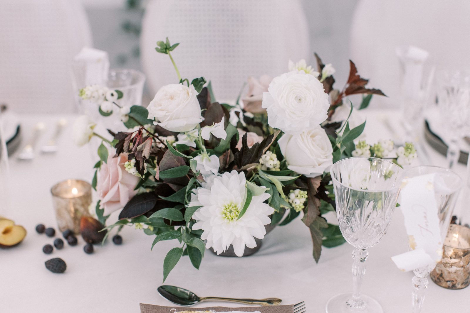 Dahlias, roses, ranunculus, snowberries, ranunculus, ninebark and smokebush used to create the elegant centrepieces for the tablescape.