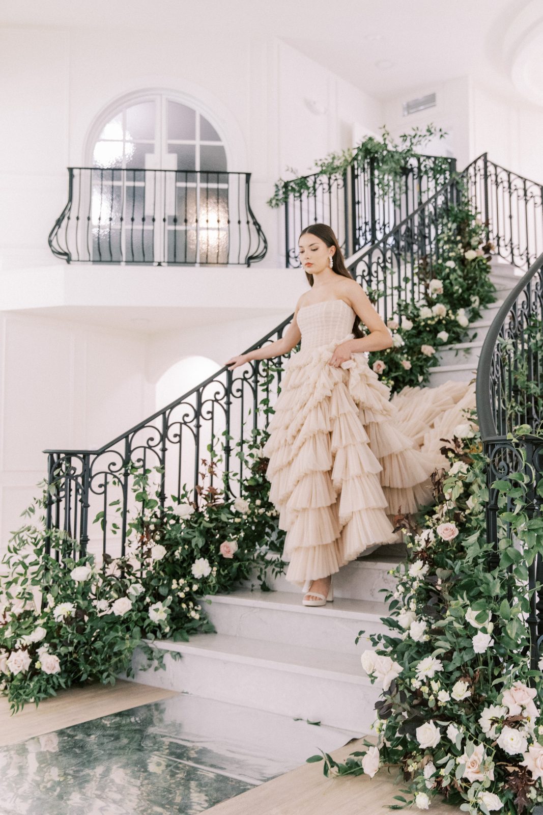 The model gracefully coming down the stairs in the stunning nude bridal gown.