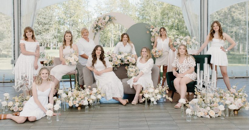 Feature Thin The expert staff of Calyx Floral Design, all dressed in white smiling together, surrounded by flowers.