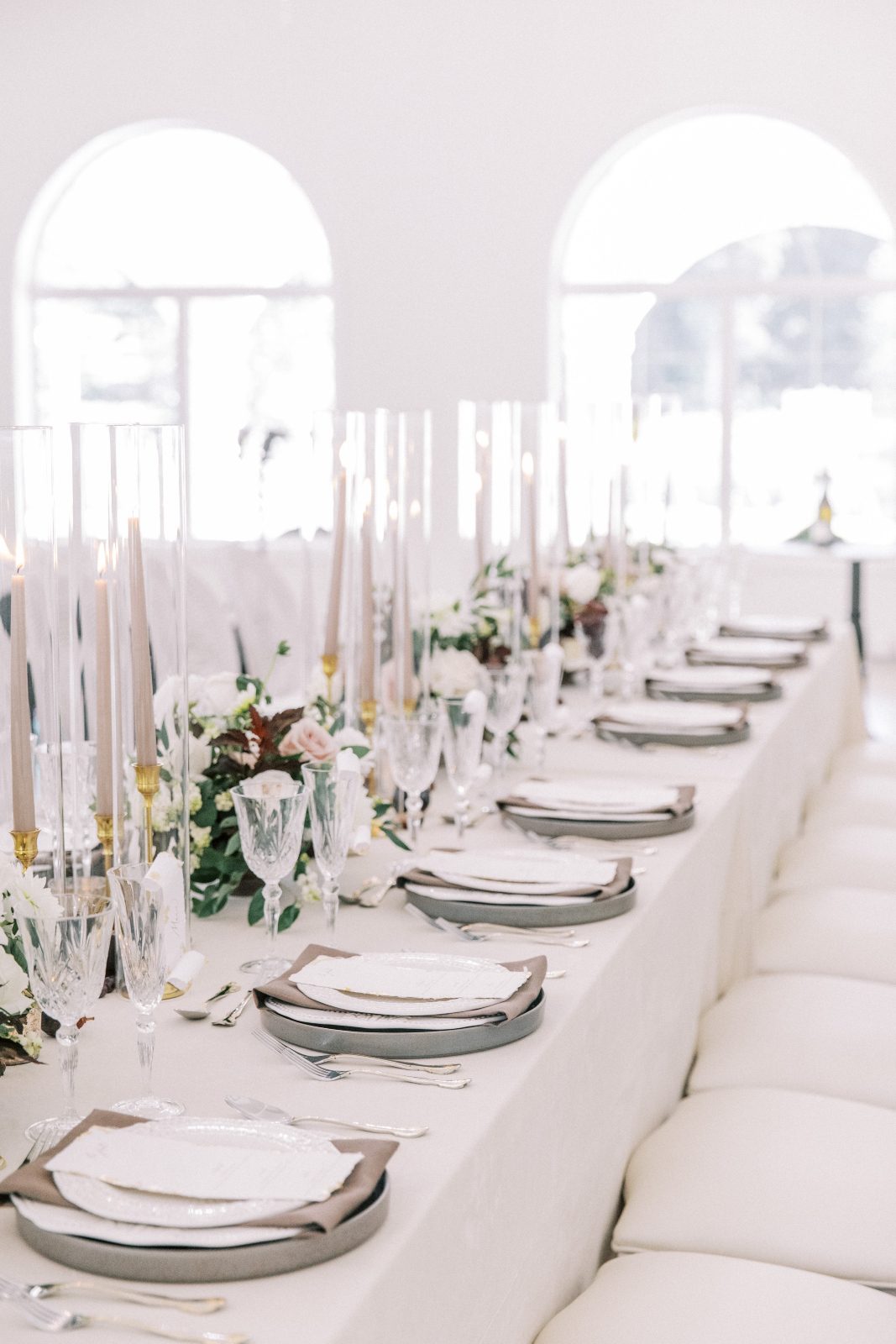 The length of the tablescape backlit by big, gorgous arched windows streaming in natural light.