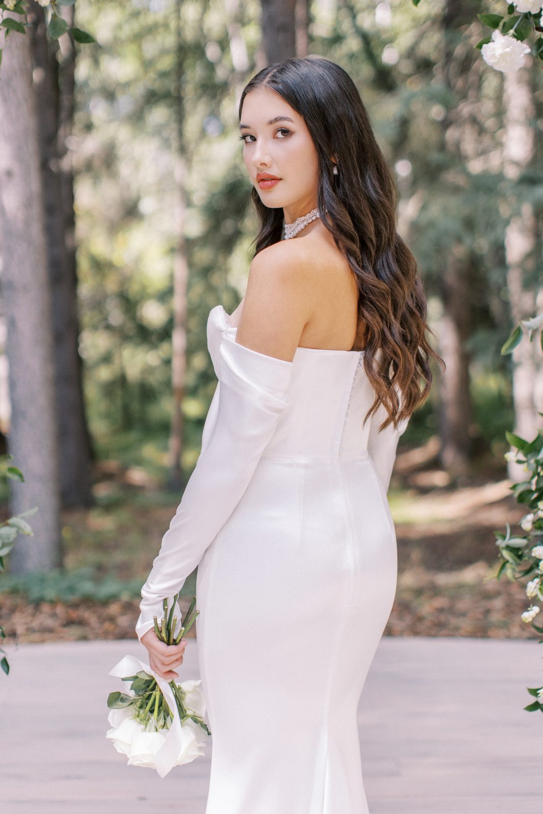 A sleek elegant gown draping beautifully over the models gentle curves with stylish detached sleeves.
