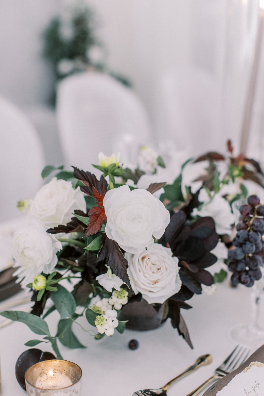 Stunning centrepiece featuring ninebark, smokebush, ranunculus, dahlias, roses and snowberries for a timeless, romantic look