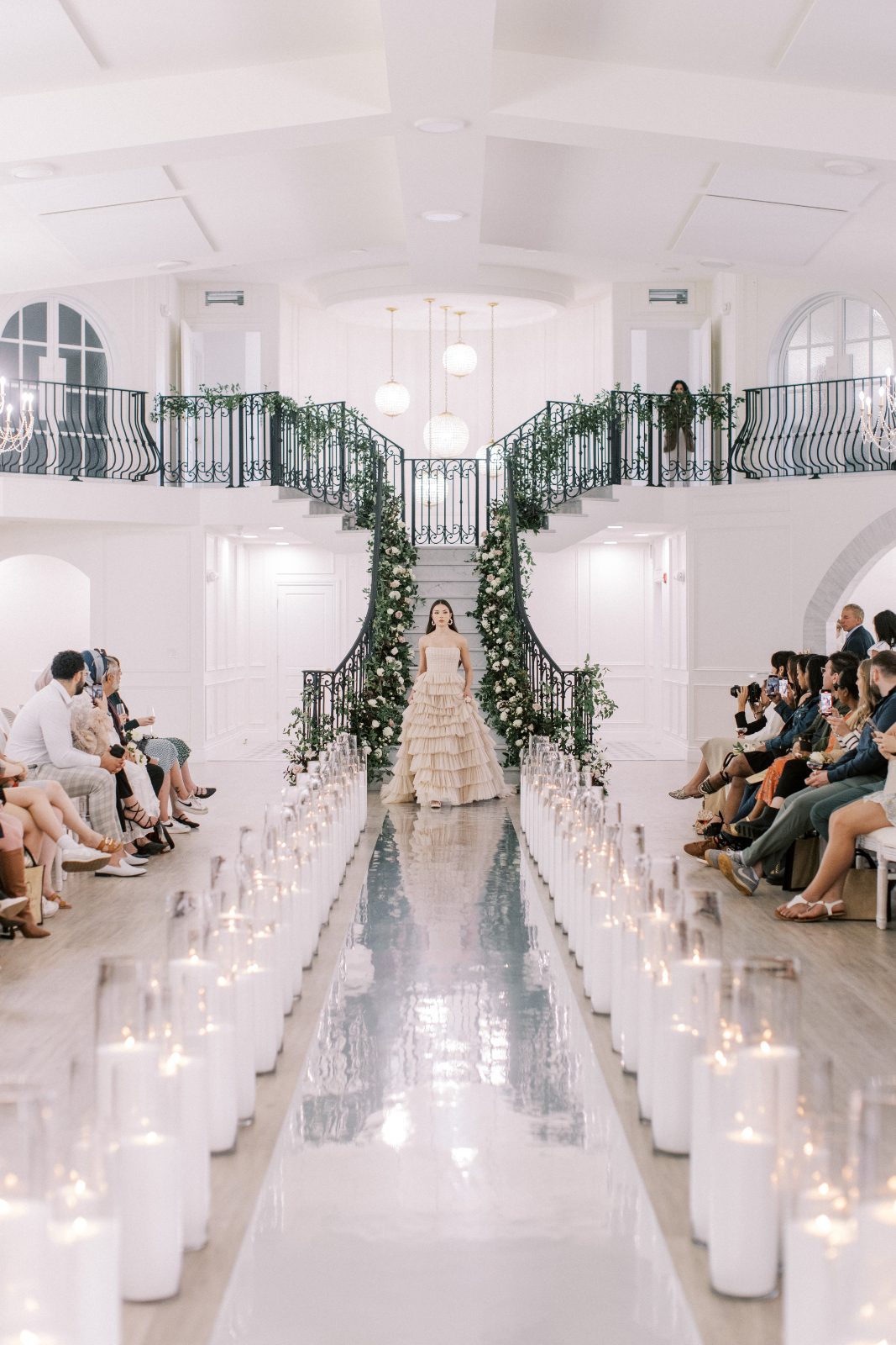 A stunning bridal gown with layers of nude tulle and fitted bodice coming down the runway.