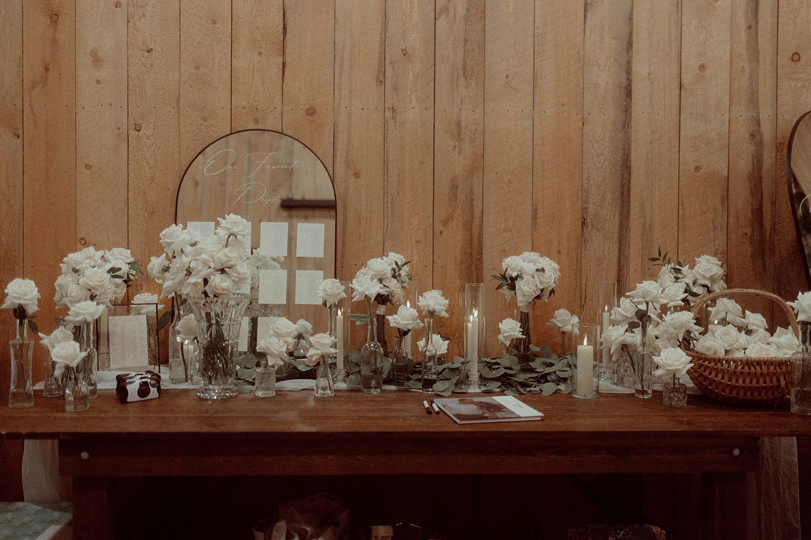 The guestbook table was adorned with greenery, vases with the bridal bouquets and candlelight.