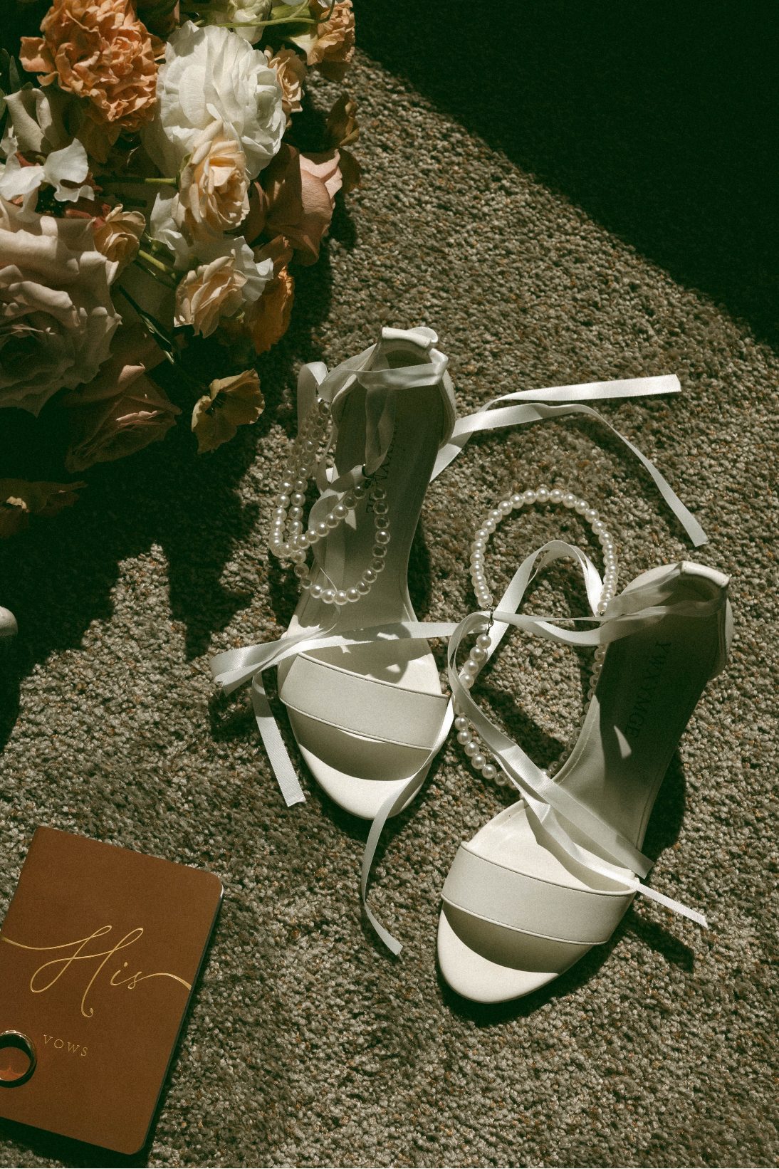 A collection of bridal accessories including the Calyx bridal bouquet, brides shoes, bracelet and vows.