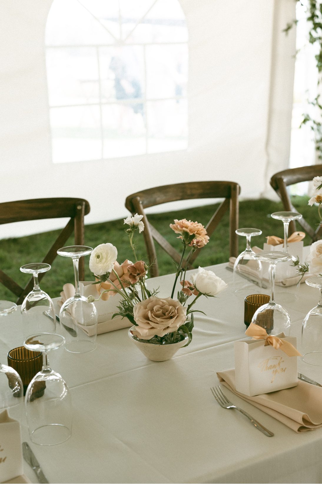 Rectangular tables featuring peach and blush ikebana inspired centrepieces and amber glass tea lights.