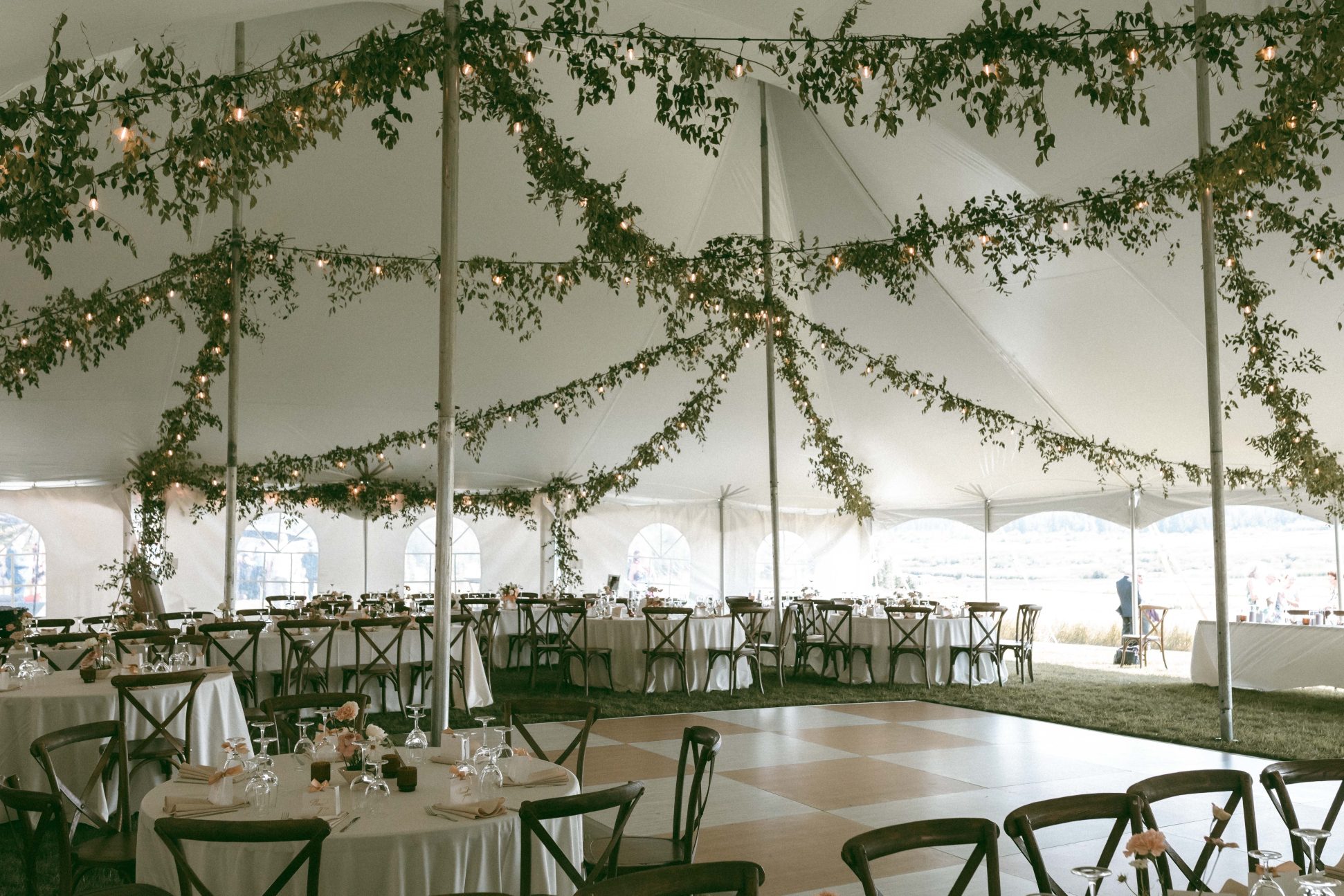 Gorgeous ceiling installation in the tent for the reception with strings of lights and greenery draping beautifully.