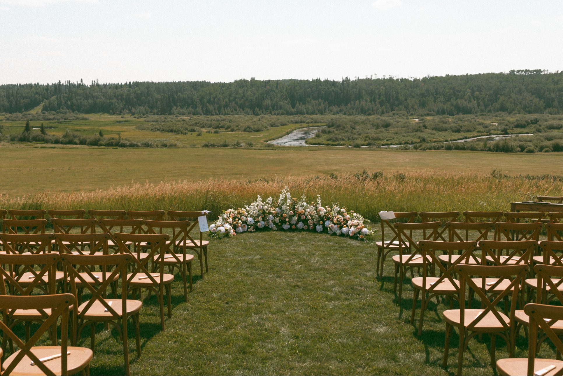 A stunning ground arch at the end of the aisle with thoughtfully constructed layers of romantic blooms.
