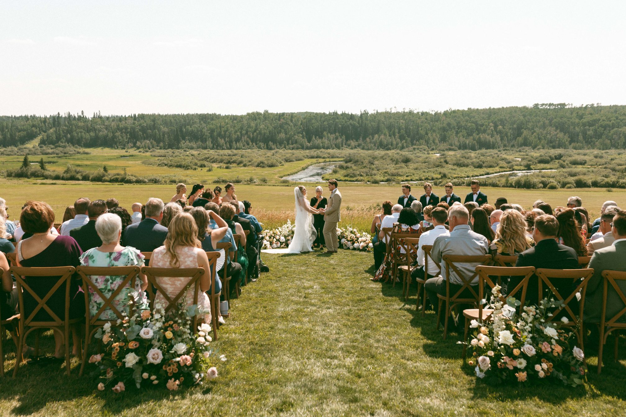 Gorgeous ceremony with gorgeous aisle marker arrangements, ground arch, beautiful couple and amazing views from the family property.