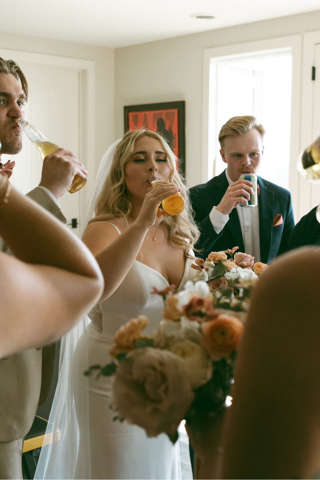 The wedding party share a drink together.