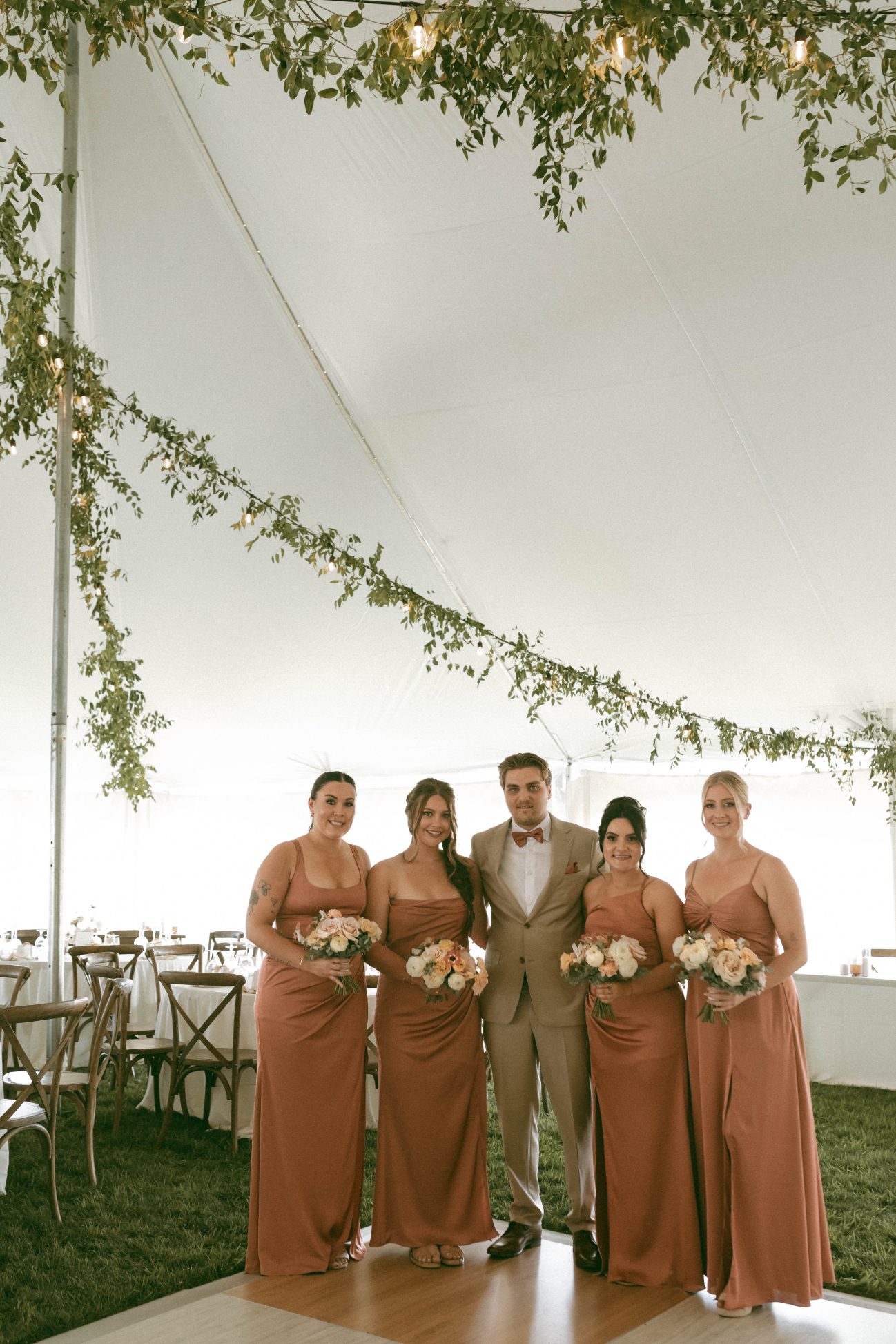 Connor poses with all the beautiful bridesmaids in their terracotta satin gowns.