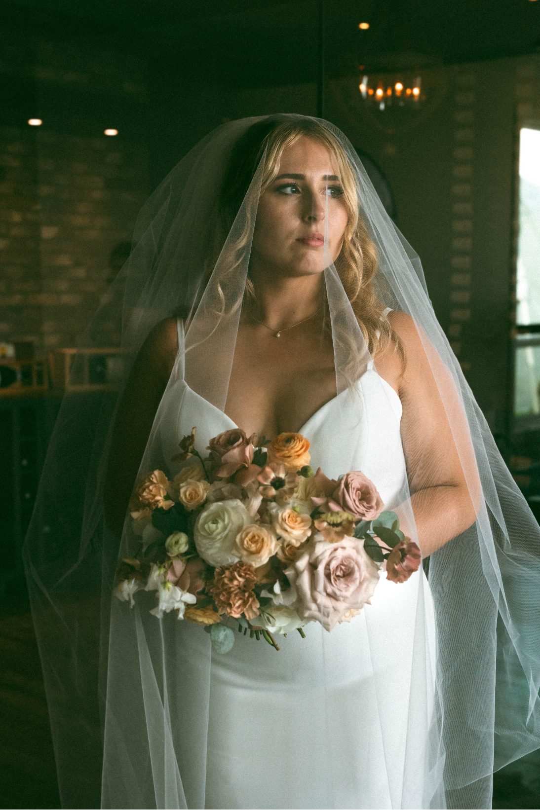 Stunning photo of Katrina with her veil over her face and bouquet looking absolutely radiant.