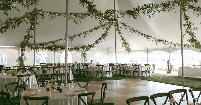 Stunning tented reception with elaborate ceiling installation of strung lights and vining foliage. Elegant tables with ikebana inspired centrepieces and beautiful details.