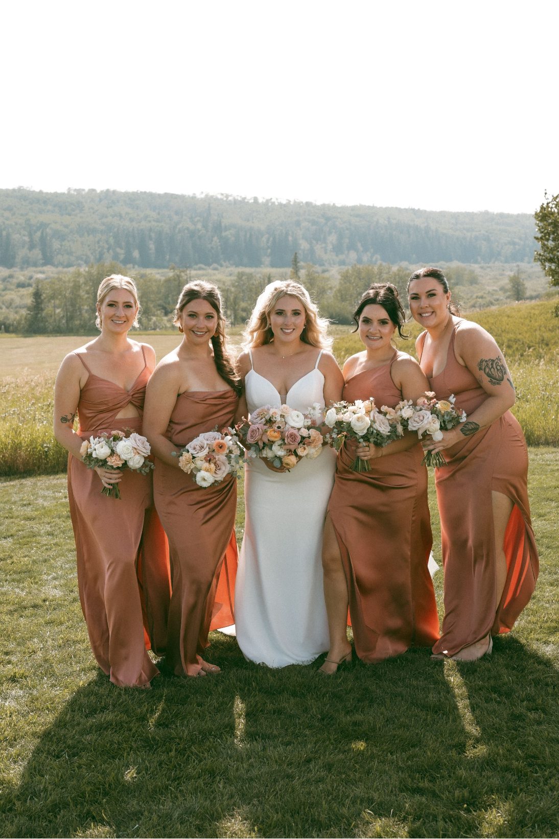 Stunning Calyx bride and her maids lined up, looking radiant and smiling.