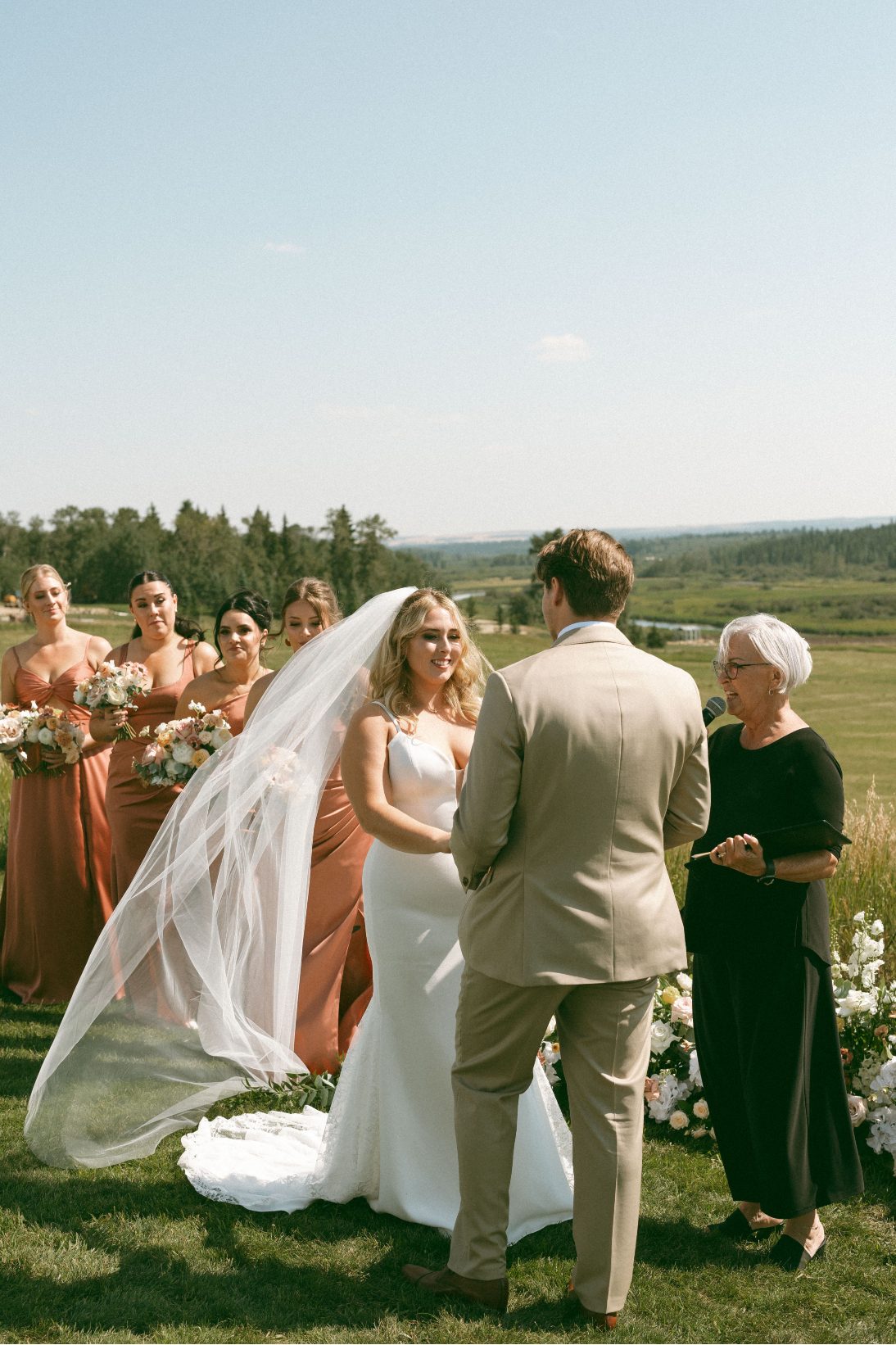 Katrina's veil gently blows in the wind during the ceremony.