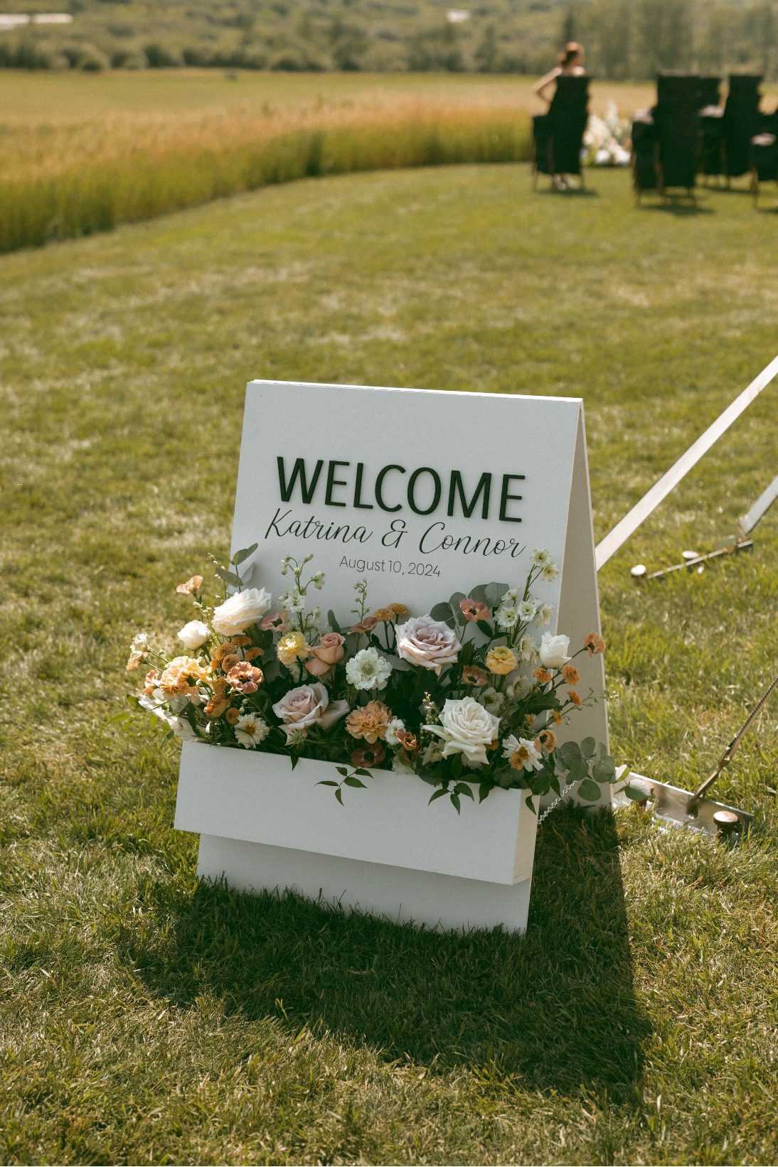 A sweet wedding sign greeting the guests as they arrived overflowing with romantic blooms in blush, peach and ivory.