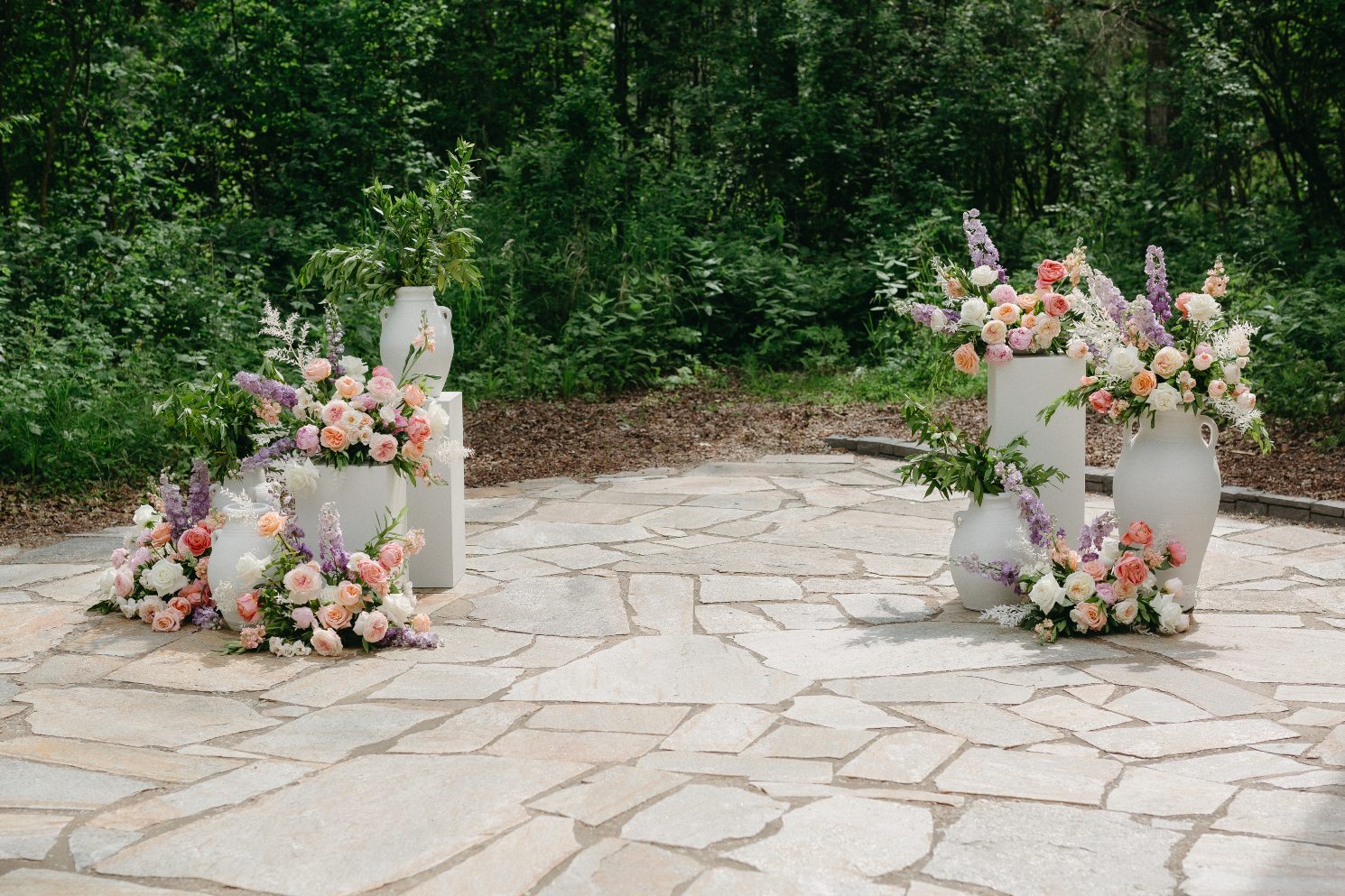As an alternative to an arch, a cluster of arrangements in urns and on pillars on either side of the alter to frame the couple during the ceremony.
