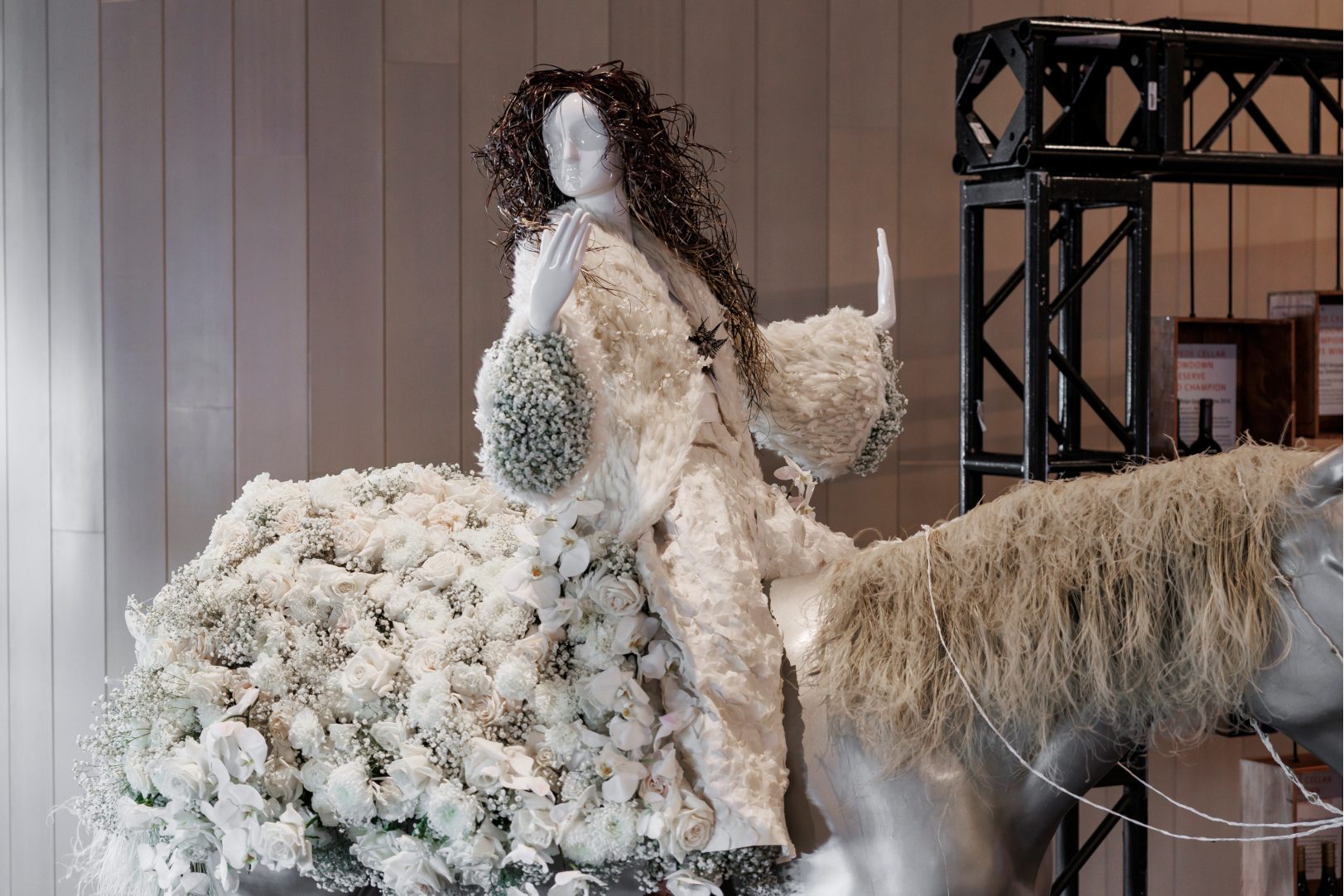 Side view of Shania Twain floral mannequin riding a silver horse, highlighting the floral jacket at the Calgary Stampede Fleur de Villes event.