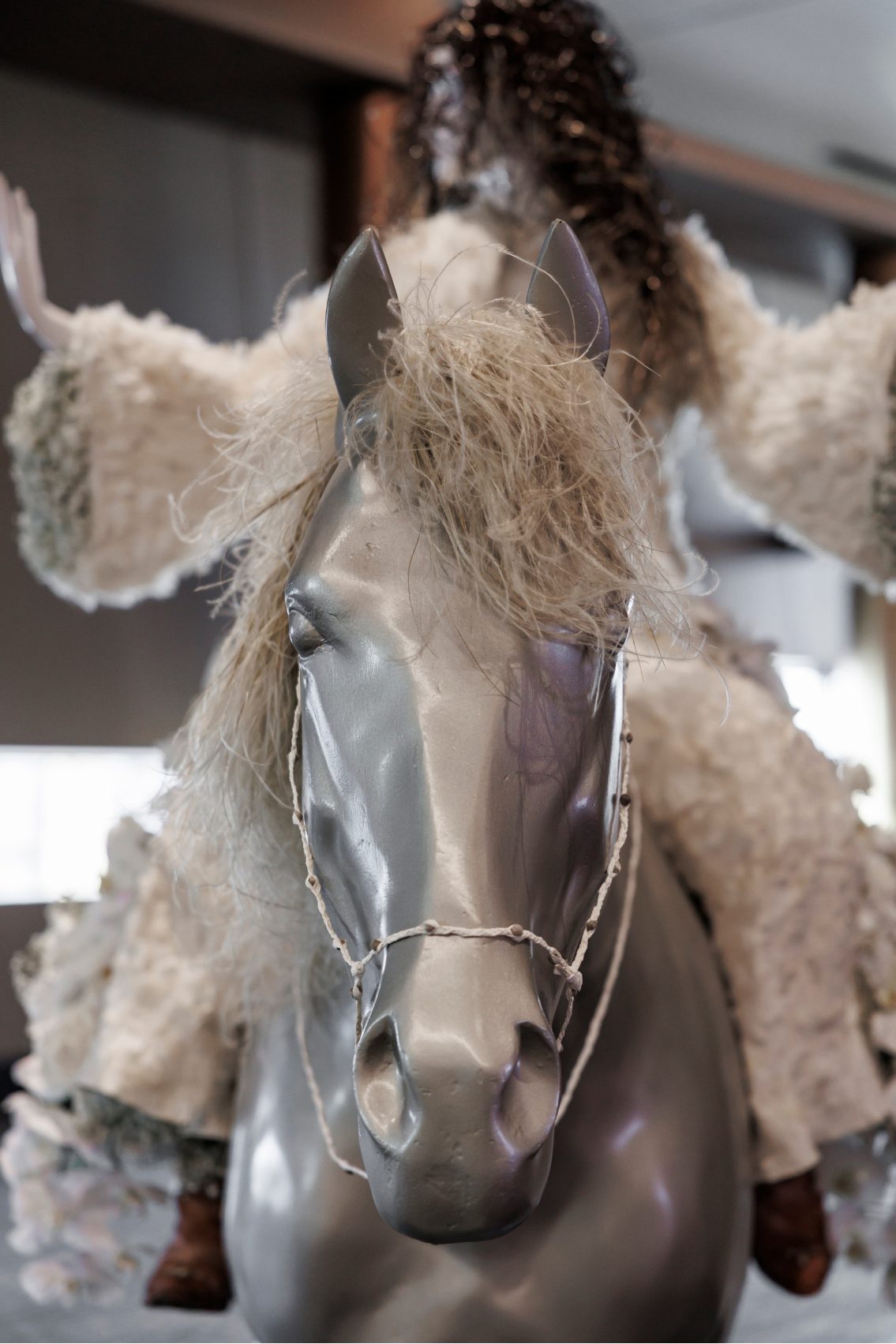 Front view of silver horse with preserved grasses for it's mane and Shania Twain mannequin riding, part of the Fleur de Villes installation at Calgary Stampede