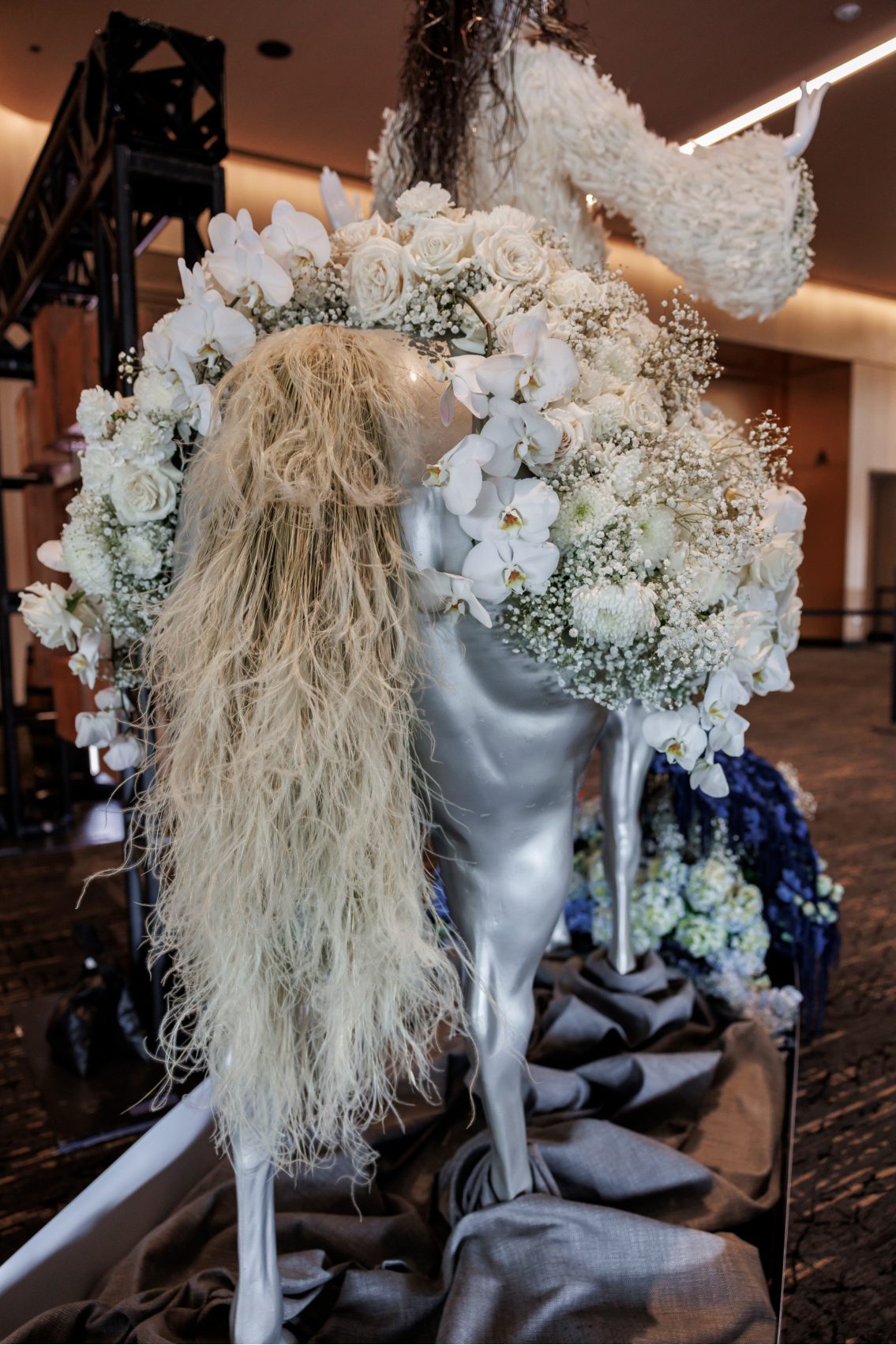 Back view of the silver horse with flowing preserved grasses for the tail, surrounded by a cascade of white blooms.