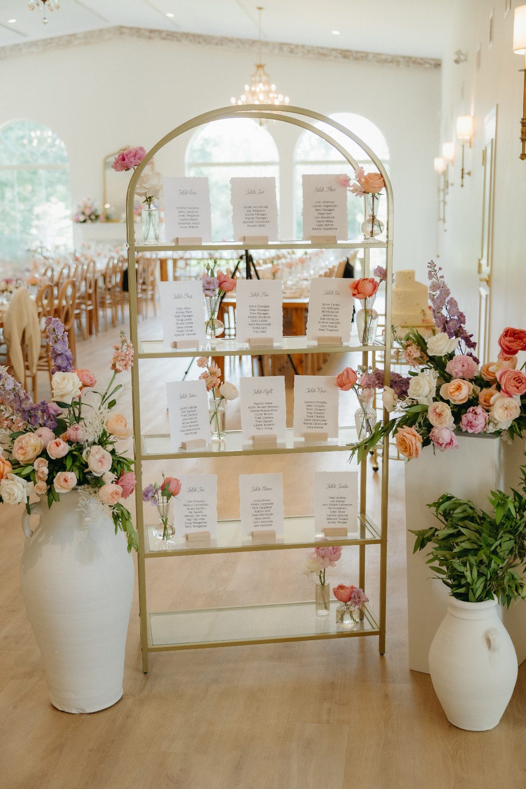 The alter arrangements repurposed to highlight the seating chart, with sweet bud vases displayed between the list for each table.