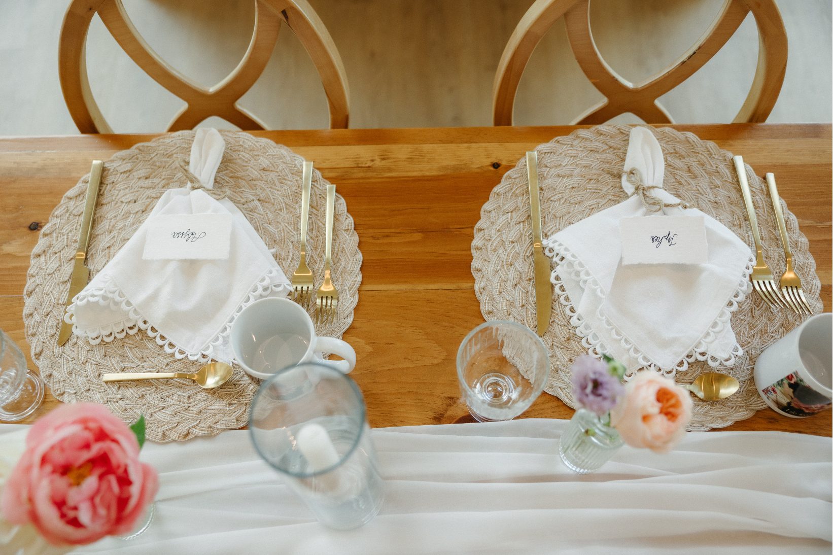 View of the table from above showing some of the thoughtfully planned details - the lace lined napkins, gold accented cutlery, ivory table runner and and elegant glassware.