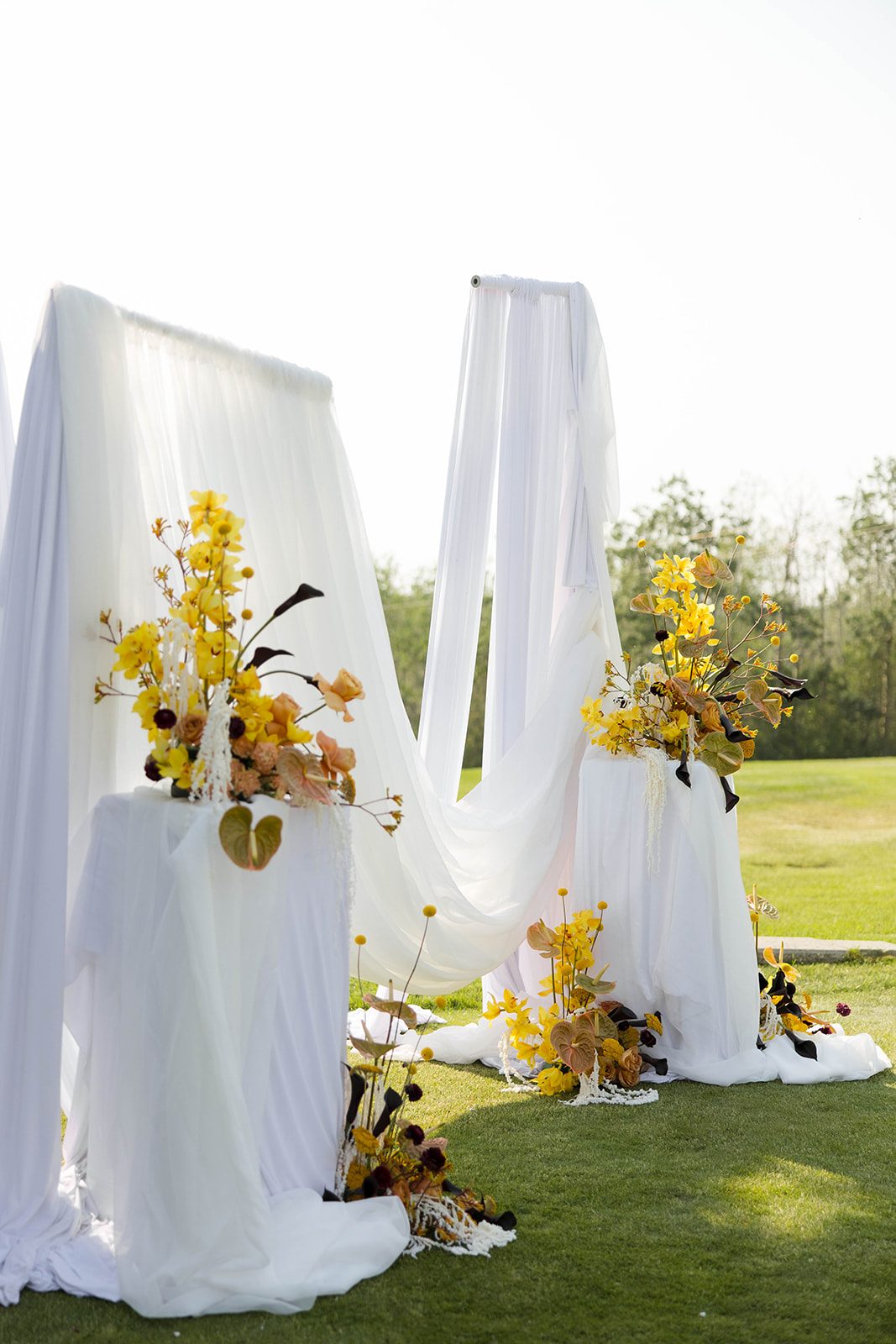 The ceremony set up viewed from the side with sun light streaming through the billowing white fabric.