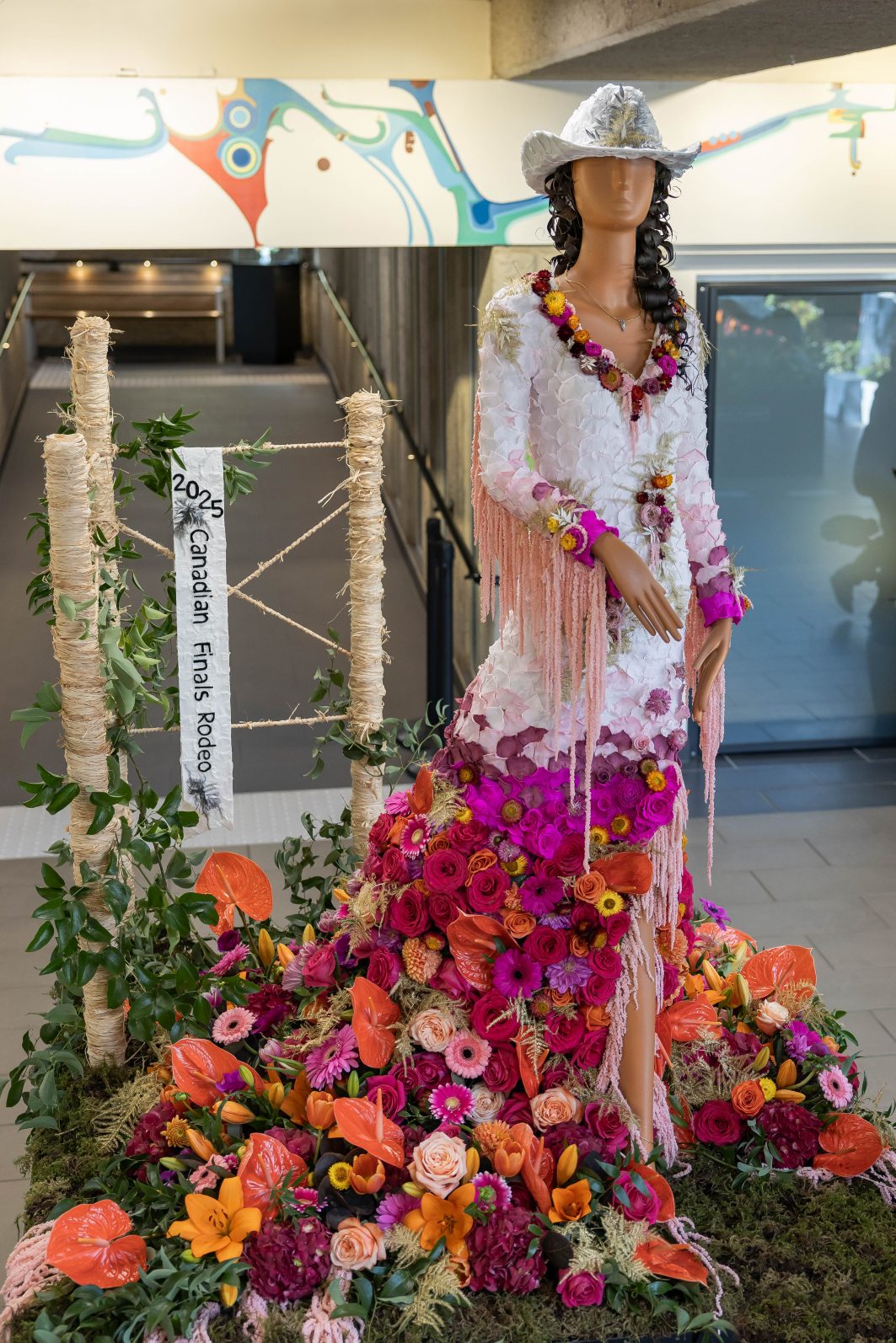 Fleur de Ville event in Edmonton featuring a cowgirl with the skirt of her dress made up of a mixture of pink and orange blooms