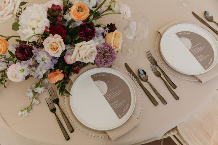 Place setting for one of the "guest tables" at Hilltops open house, featuring a beautiful centrepiece in blush, peach, purple and burgundy with beautifully coordinated place setting, linen and menu.