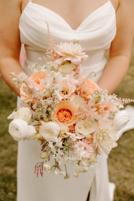 A stunning Calyx bouquet to match the ceremony flowers of the previous picture, in ivory blush and peach with garden roses, dahlias, ranunculus, astilbe and other pretty blooms.